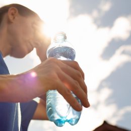 Une femme boit de l'eau pendant la canicule