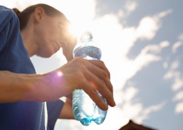 Une femme boit de l'eau pendant la canicule